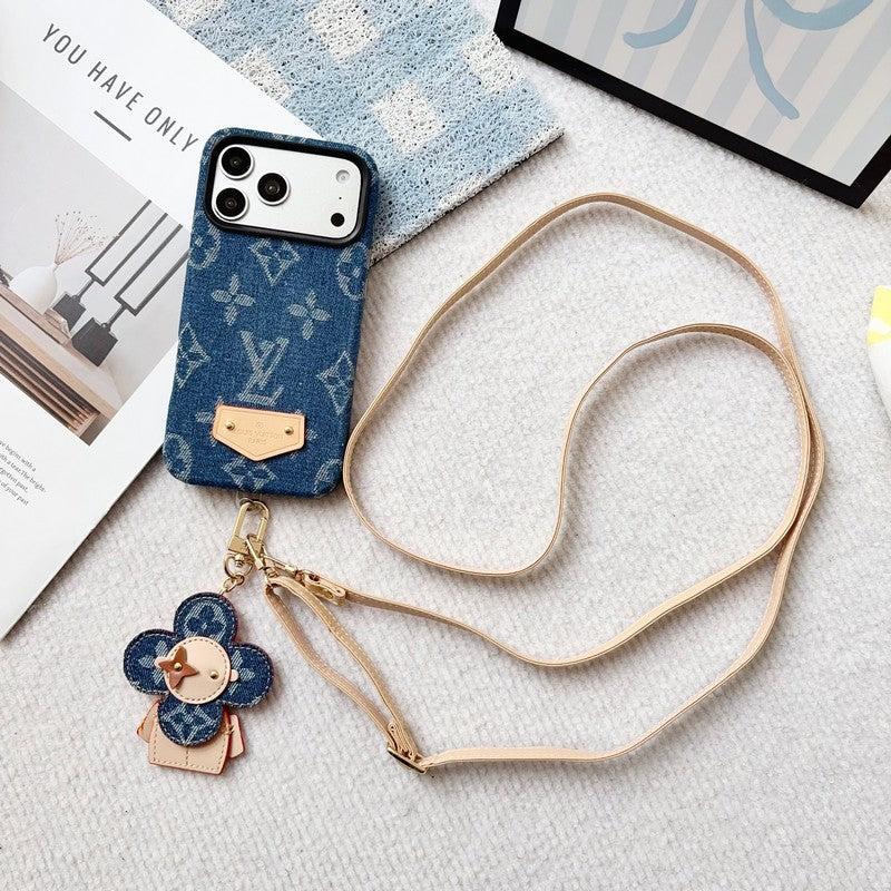 Blue phone case with a strap and charm on a textured surface