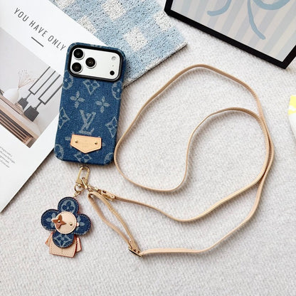 Blue phone case with a strap and charm on a textured surface